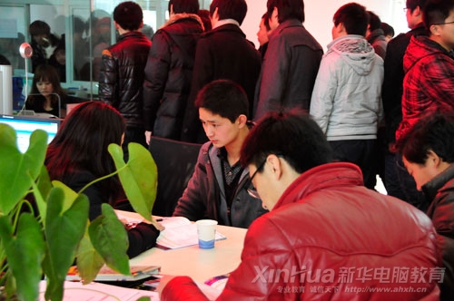 新華咨詢中心內(nèi)，男孩專注地聽老師介紹專業(yè)